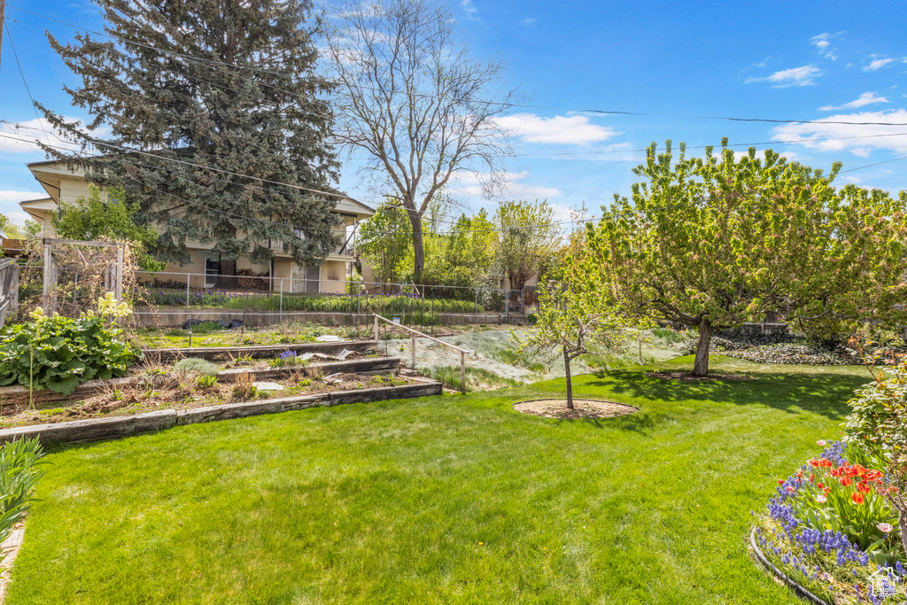 View of yard with fence and a garden