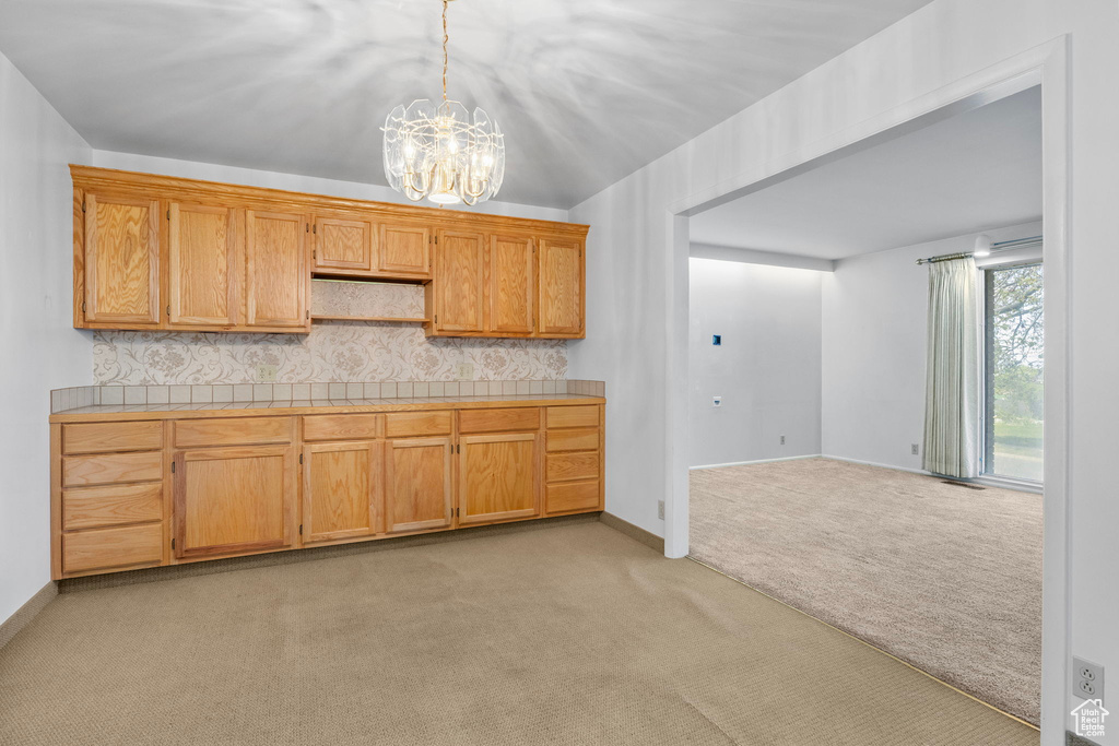 Kitchen with backsplash, pendant lighting, open shelves, an inviting chandelier, and light carpet
