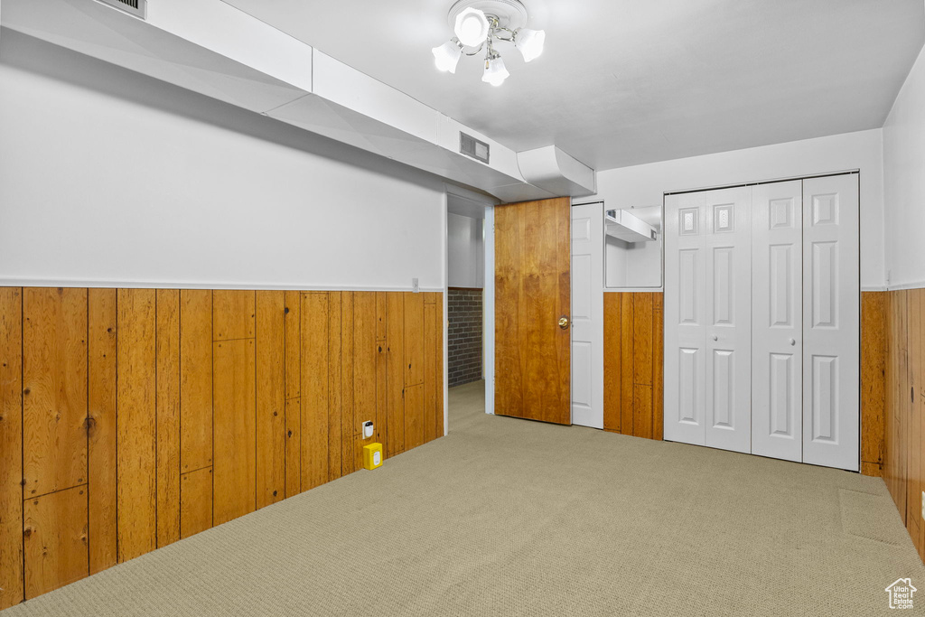 Interior space with visible vents, wood walls, wainscoting, and carpet flooring