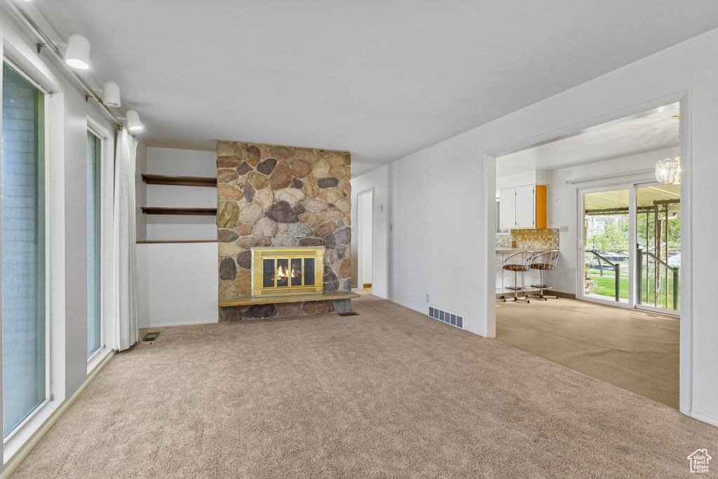 Carpeted living area with visible vents and a fireplace