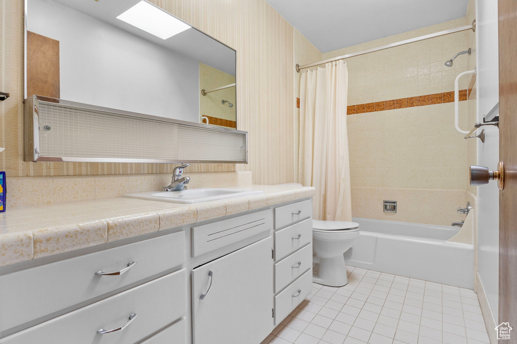 Full bathroom with vanity, tile patterned flooring, toilet, and shower / bathtub combination with curtain