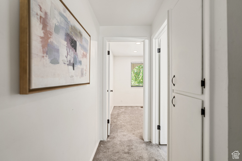 Corridor with carpet flooring and baseboards