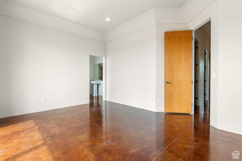 Spare room with ornamental molding and finished concrete flooring