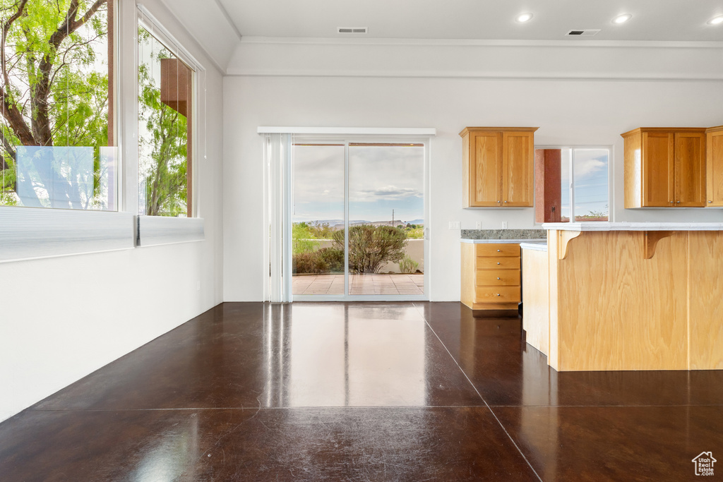 Kitchen with light countertops, ornamental molding, a kitchen bar, and visible vents