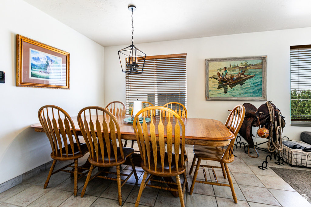 Dining space with baseboards, a chandelier, and light tile patterned floors