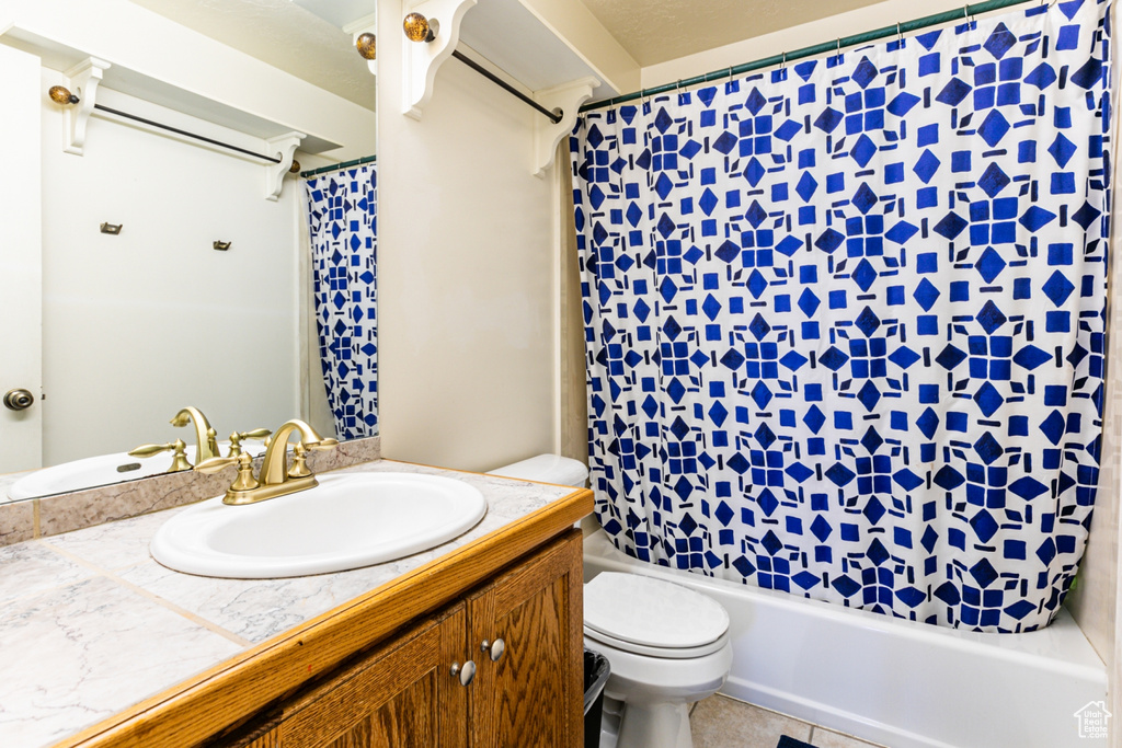 Full bath featuring toilet, vanity, and shower / bath combo with shower curtain