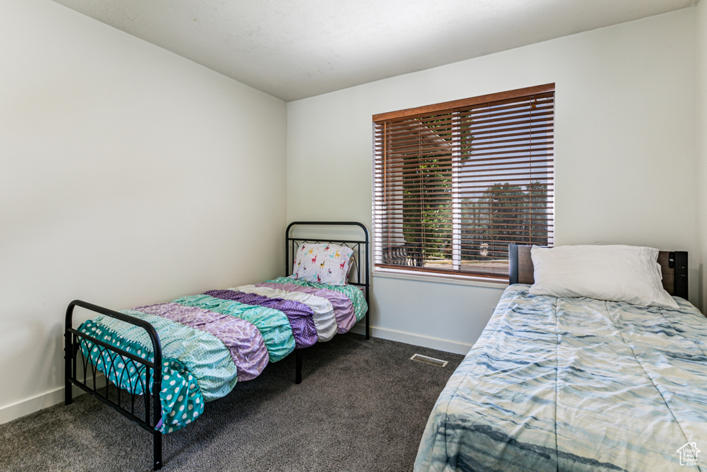 Carpeted bedroom with baseboards and visible vents