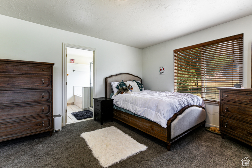 Bedroom featuring dark carpet and ensuite bathroom