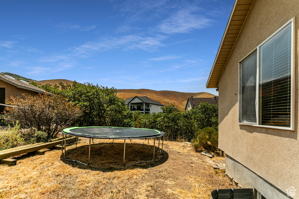 View of yard featuring a trampoline and a mountain view