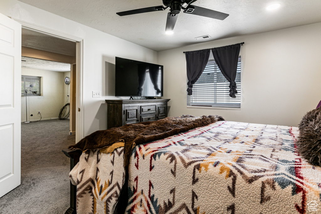 Bedroom with visible vents, a ceiling fan, and carpet flooring