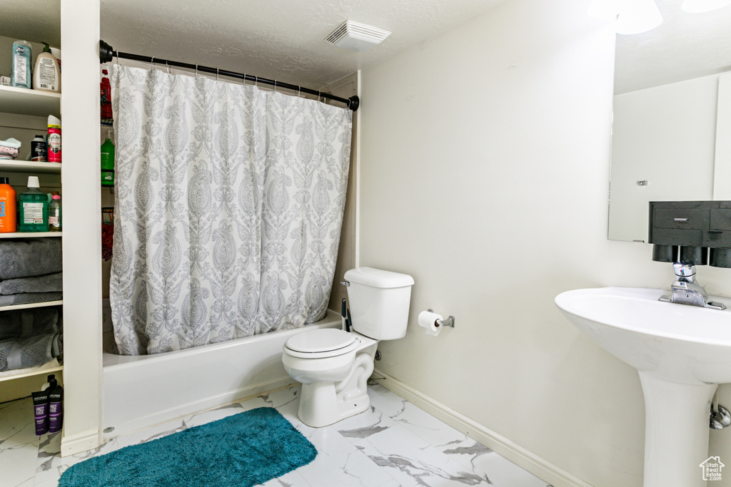 Full bathroom featuring marble finish floor, shower / bathtub combination with curtain, visible vents, toilet, and a sink