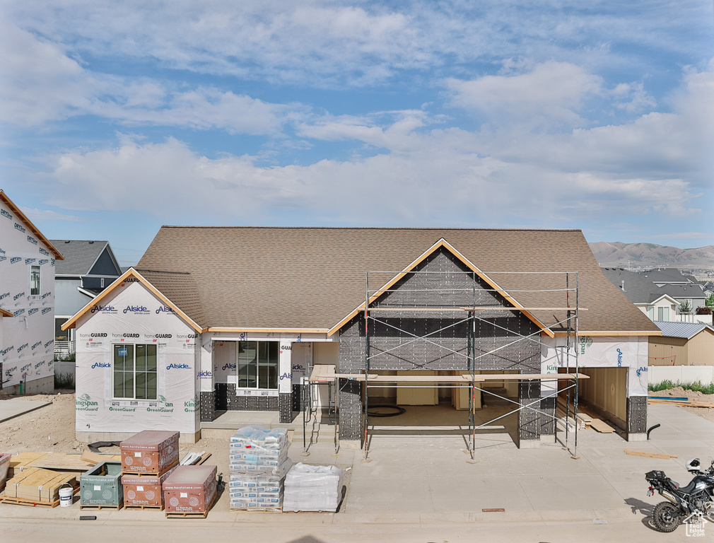 View of front of home with a shingled roof and a mountain view