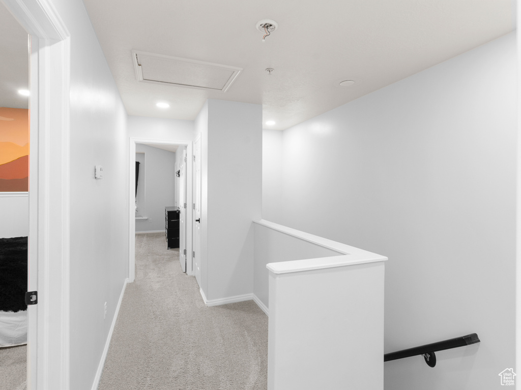 Corridor featuring an upstairs landing, light carpet, baseboards, and recessed lighting