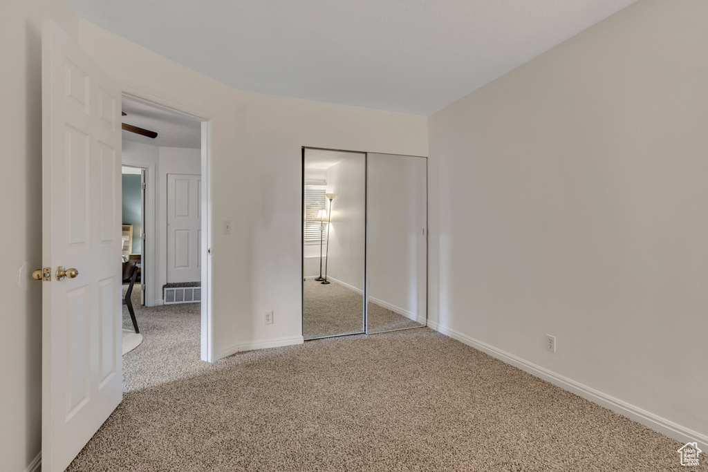 Unfurnished bedroom featuring carpet flooring, a closet, and baseboards