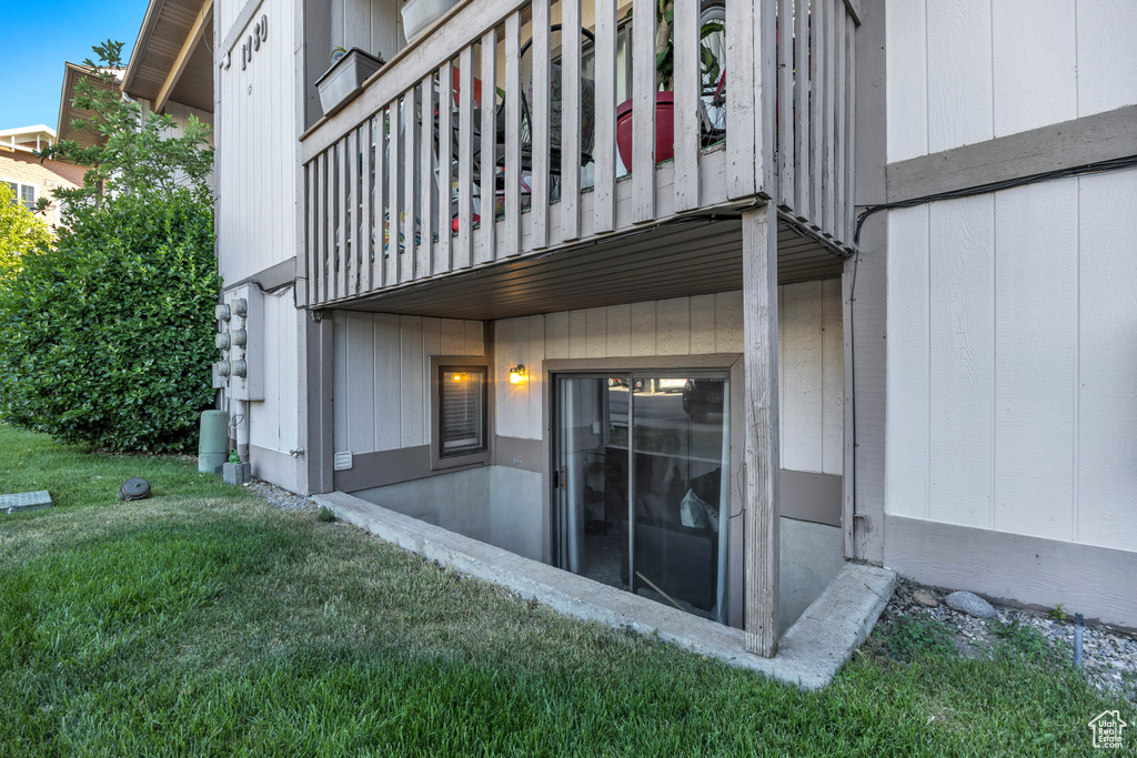 Back of property with a balcony and a lawn