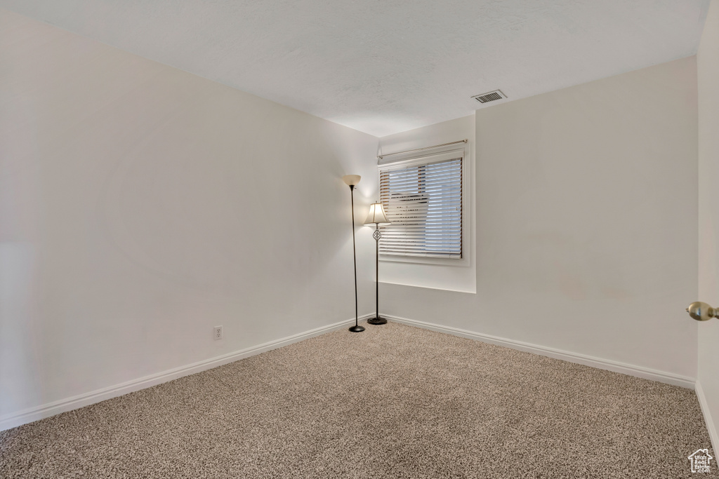 Carpeted empty room featuring baseboards