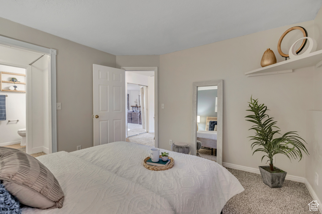 Bedroom with carpet, baseboards, and ensuite bathroom