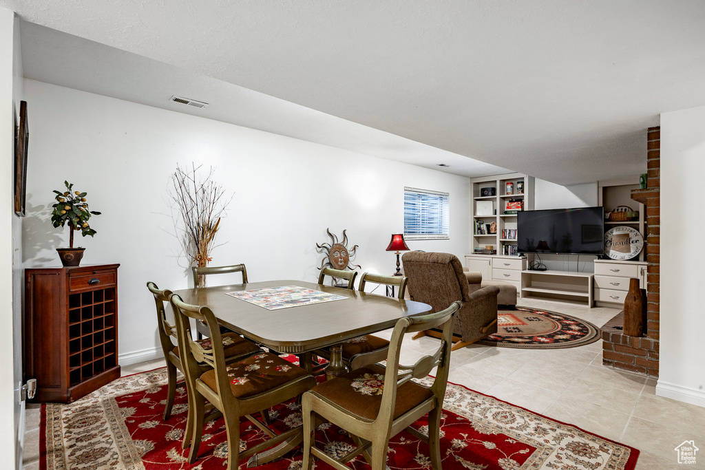 Dining room featuring baseboards, light tile patterned floors, visible vents, and built in shelves