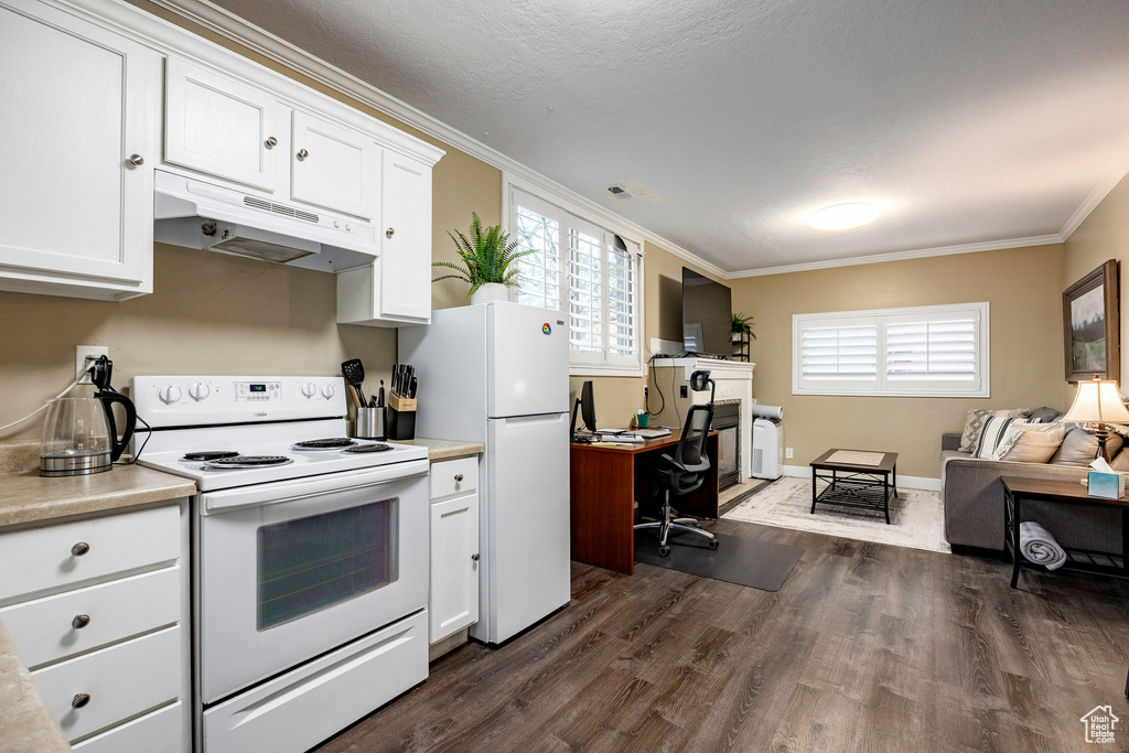 Kitchen with under cabinet range hood, white appliances, dark wood finished floors, open floor plan, and crown molding