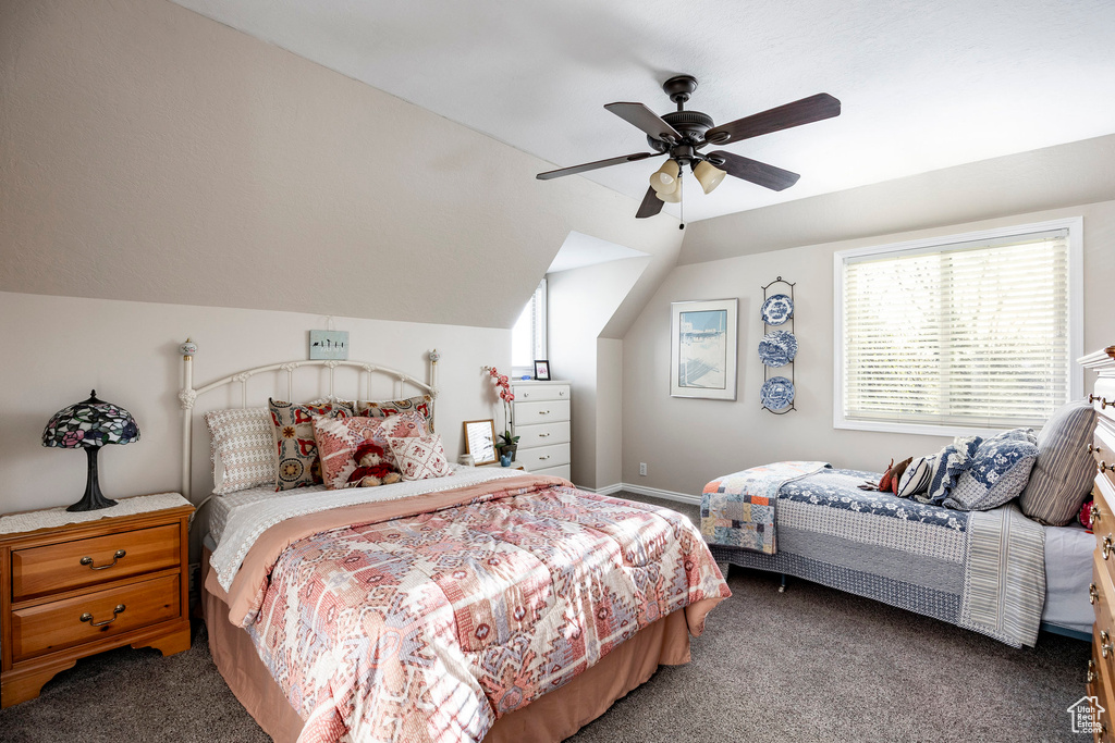 Carpeted bedroom with lofted ceiling and a ceiling fan