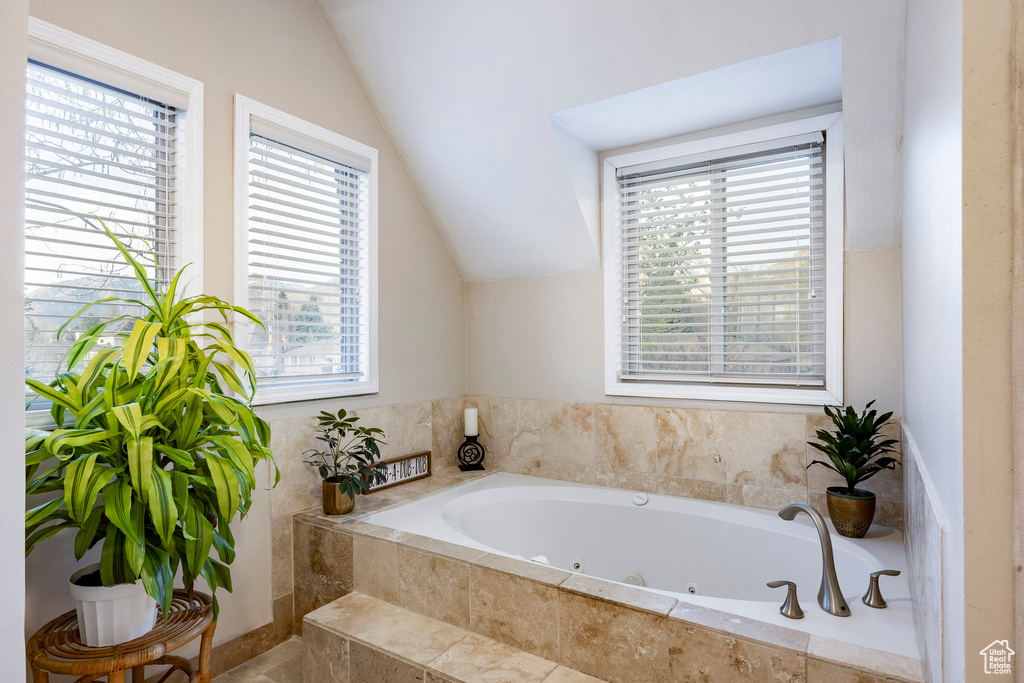 Full bath featuring a whirlpool tub and lofted ceiling