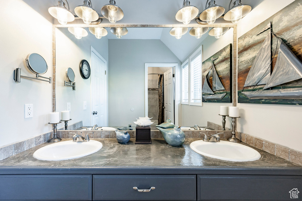 Full bathroom featuring double vanity, a sink, and a shower with shower curtain