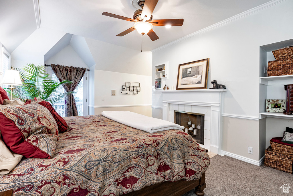Bedroom with carpet flooring, a tile fireplace, a ceiling fan, baseboards, and ornamental molding