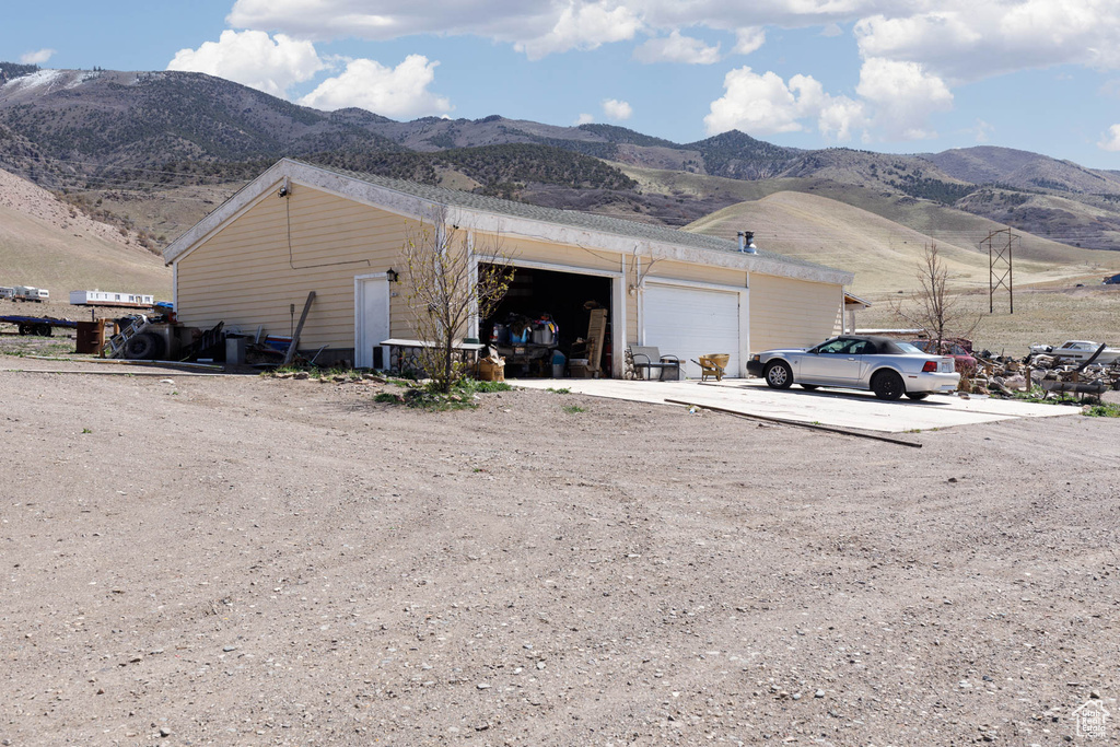 Exterior space with an attached garage, driveway, and a mountain view