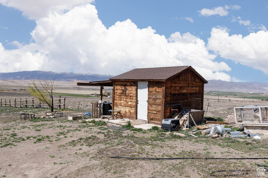View of shed with a mountain view, fence, and a rural view