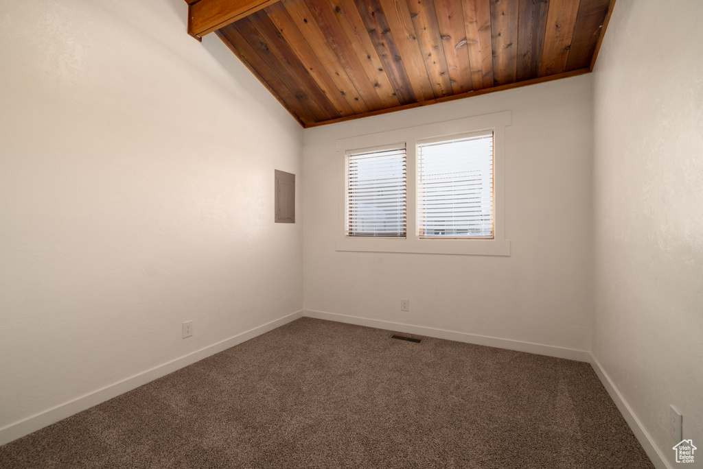 Carpeted empty room with baseboards, visible vents, lofted ceiling, and wooden ceiling
