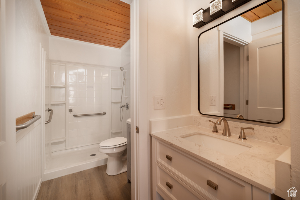 Full bathroom featuring wood finished floors, toilet, vanity, wood ceiling, and a stall shower