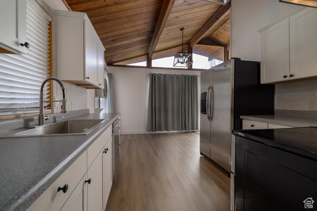Kitchen featuring a sink, backsplash, light wood-style floors, wood ceiling, and appliances with stainless steel finishes