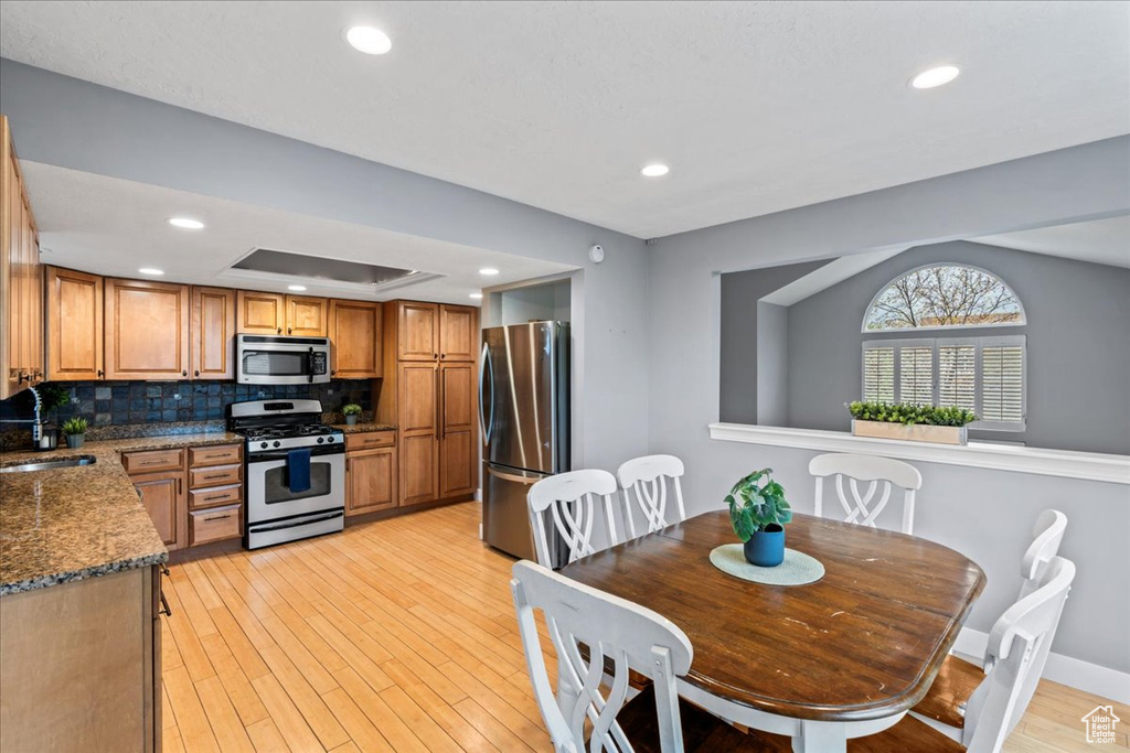 Dining area with light wood finished floors, baseboards, and recessed lighting