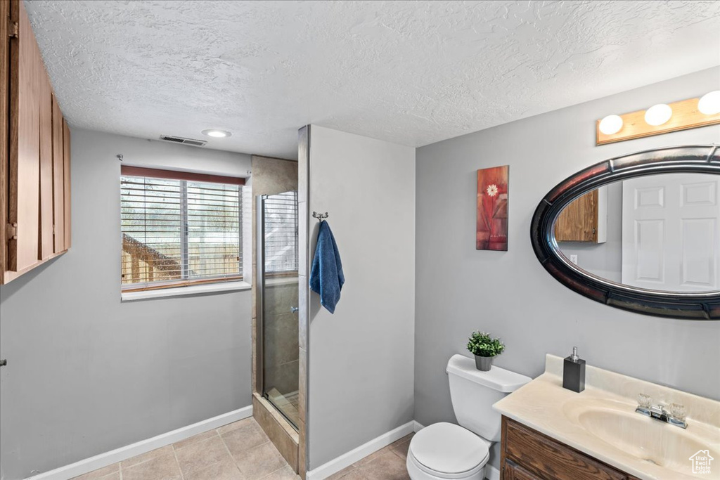 Bathroom with visible vents, toilet, baseboards, and a stall shower