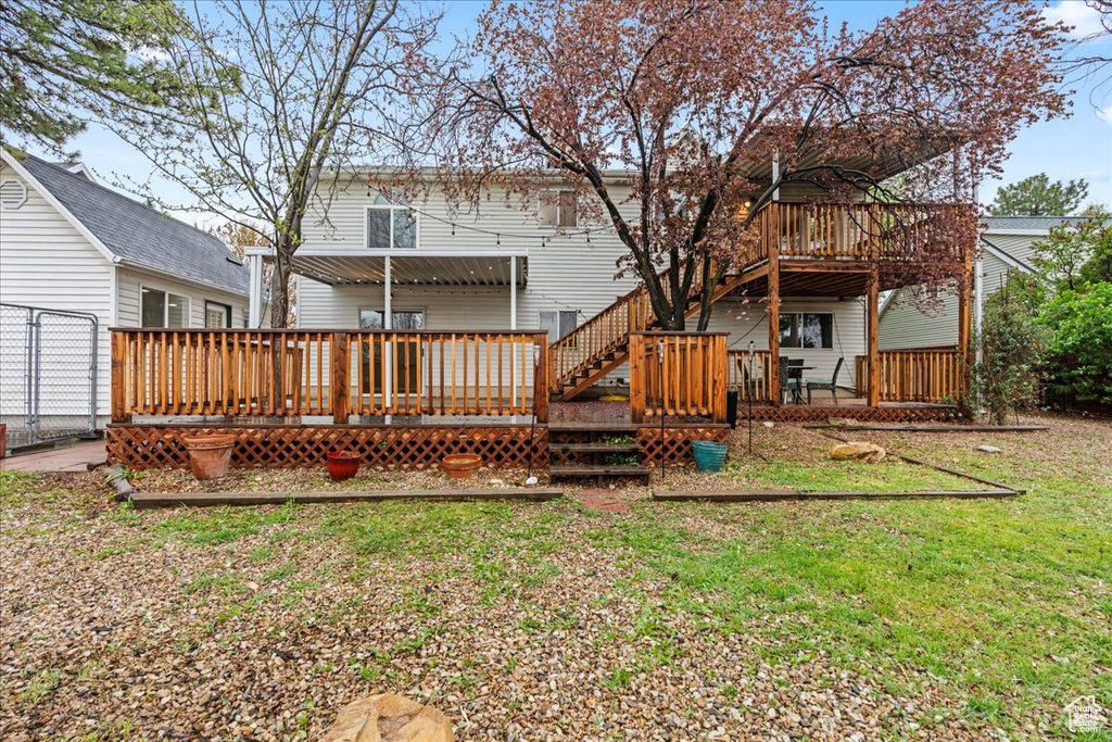 Rear view of house featuring a yard and a deck