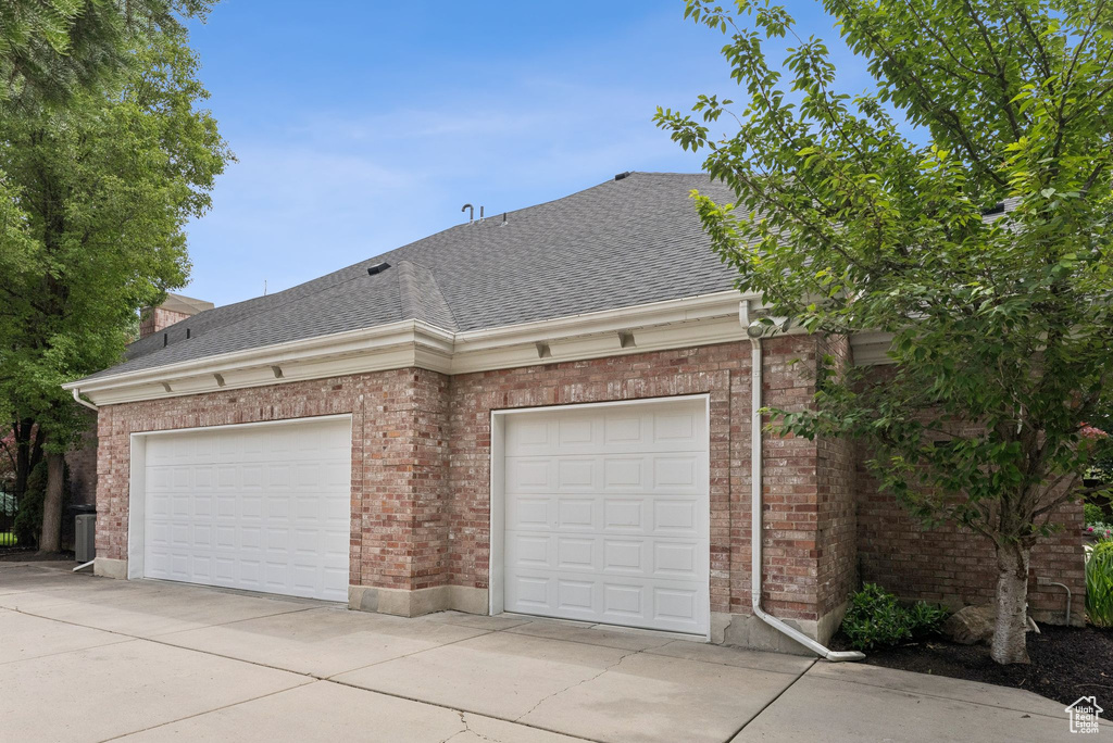 Garage with concrete driveway and central AC