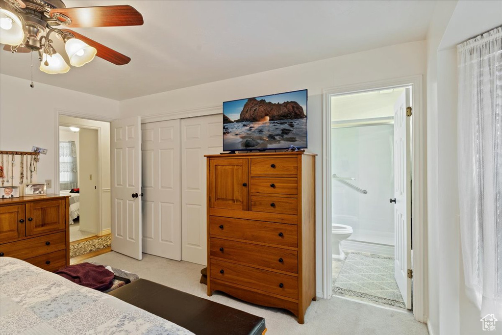 Bedroom with ceiling fan, a closet, light carpet, and ensuite bathroom