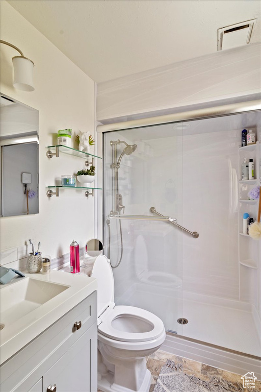 Full bath with vanity, a shower stall, and toilet