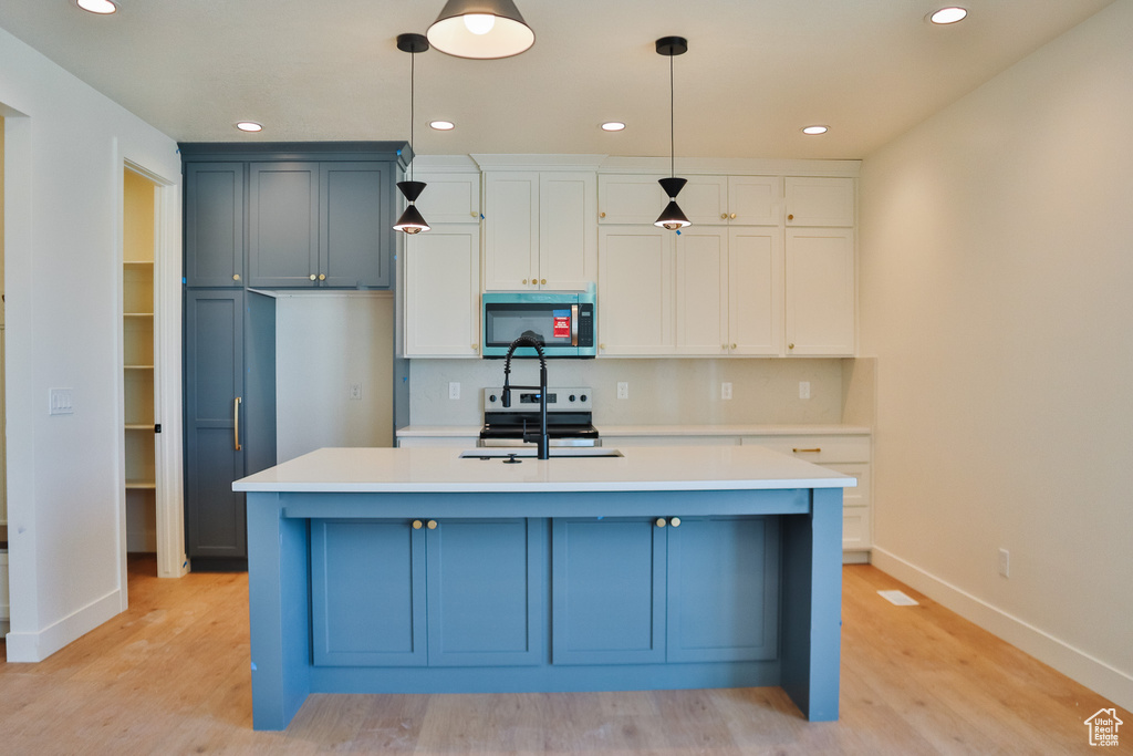 Kitchen featuring appliances with stainless steel finishes, baseboards, light countertops, light wood-style flooring, and recessed lighting