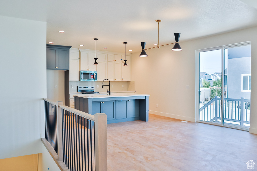 Kitchen with stainless steel microwave, light countertops, range with electric stovetop, baseboards, and recessed lighting
