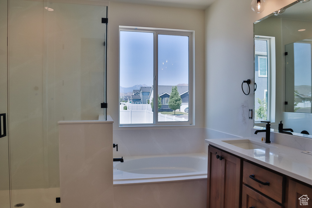 Bathroom with plenty of natural light, vanity, a bath, and a shower stall