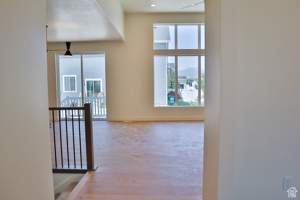 Corridor with an upstairs landing, light wood-type flooring, and baseboards