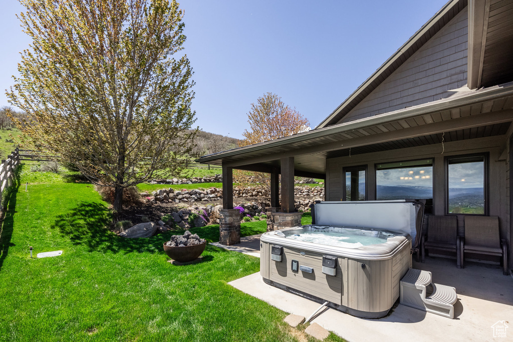 View of green lawn with a hot tub
