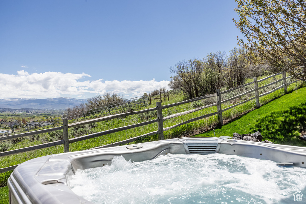 Wooden terrace with a hot tub and fence