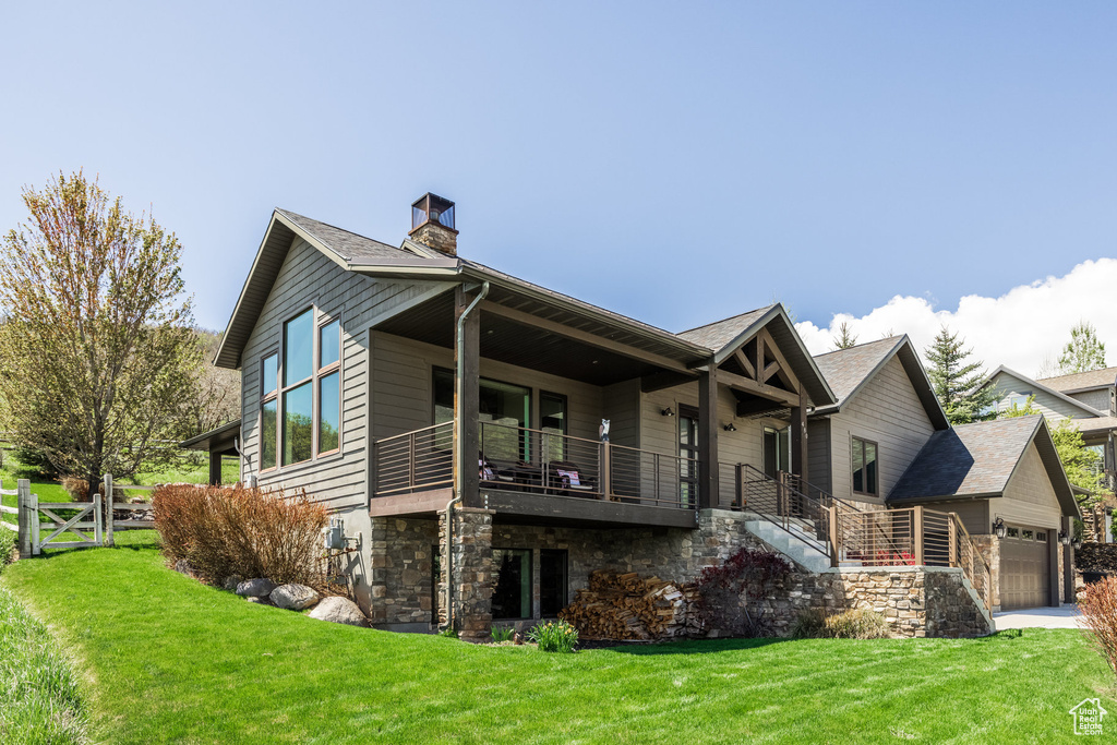 View of property exterior with a chimney, stairs, stone siding, an attached garage, and a balcony