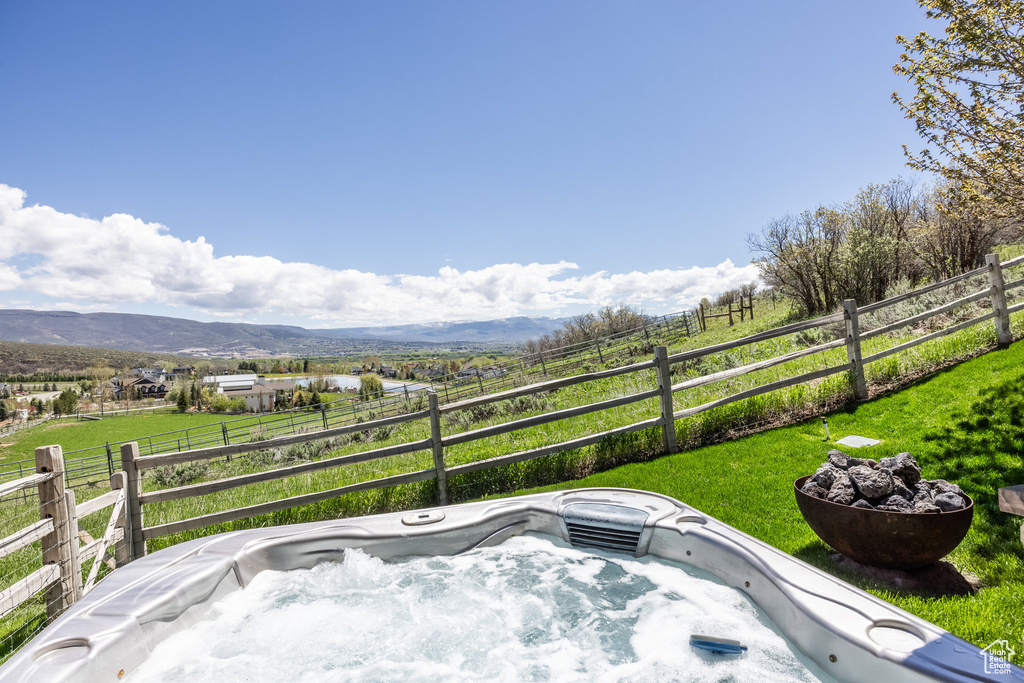 View of yard with a hot tub, a mountain view, and a rural view