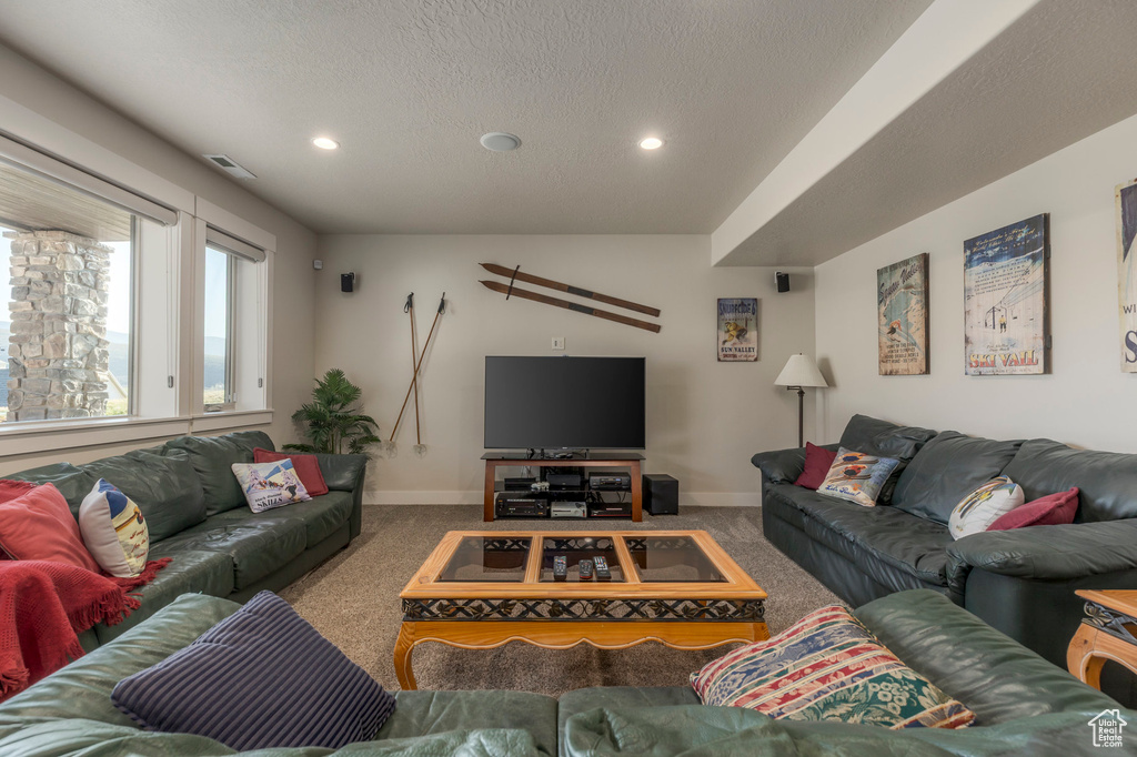 Living area with carpet flooring, recessed lighting, a textured ceiling, and baseboards