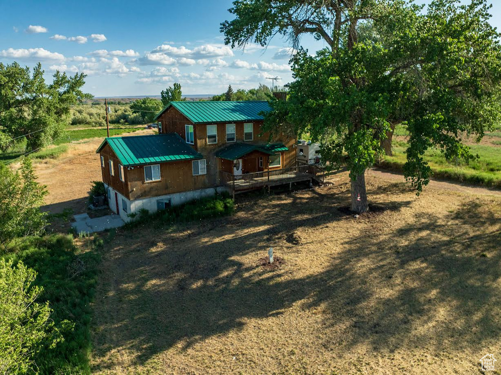 Back of property featuring a deck and a metal roof