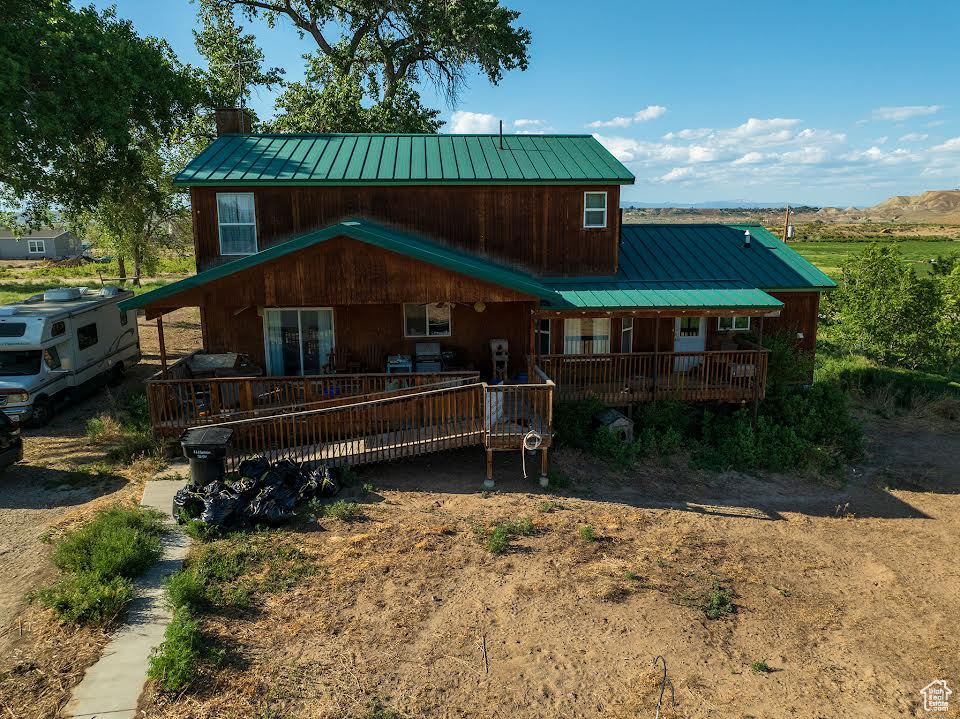 Rustic home with a metal roof, covered porch, and a standing seam roof