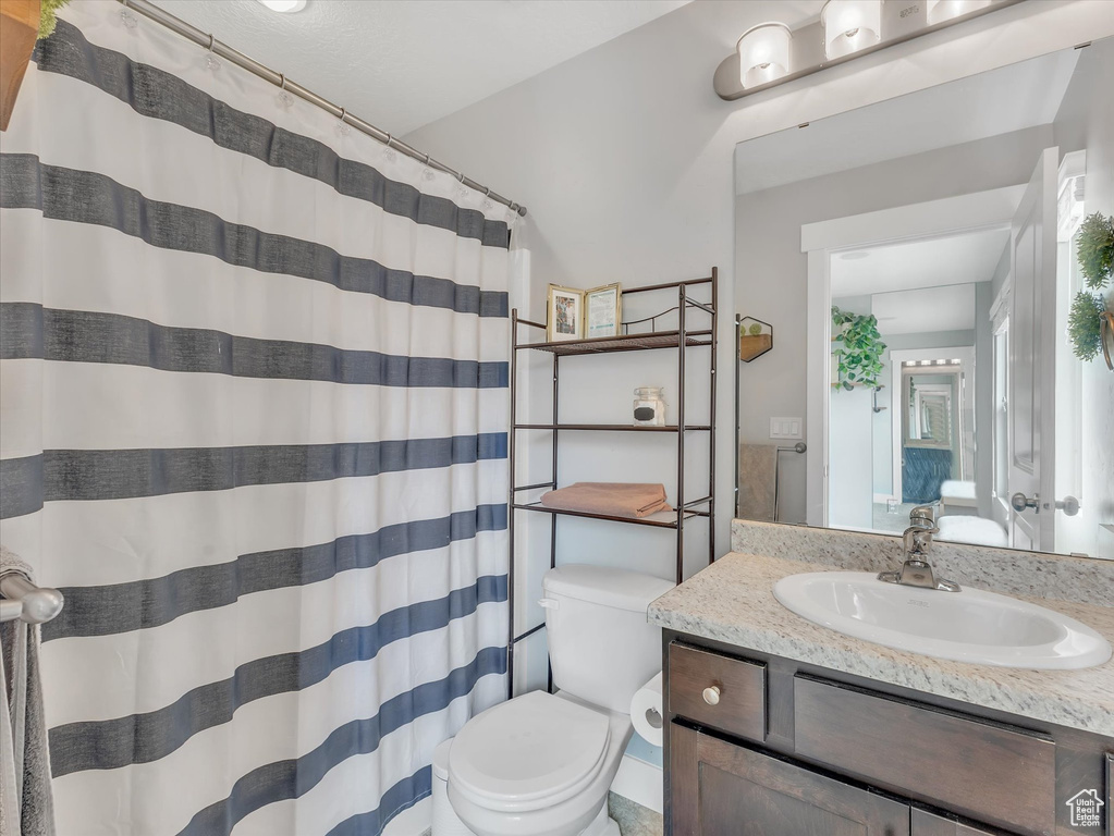 Full bathroom with a shower with curtain, vanity, and toilet